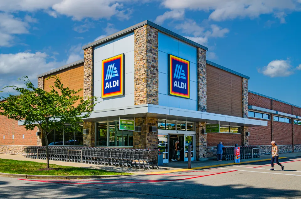 Aldi storefront with customer traffic and cart return area
